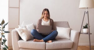 Online life. Young woman chatting with friend on laptop at home, panorama