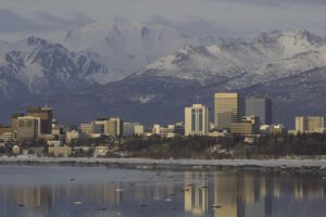 The setting sun illuminates Anchorage and reflects off Cook Inlet